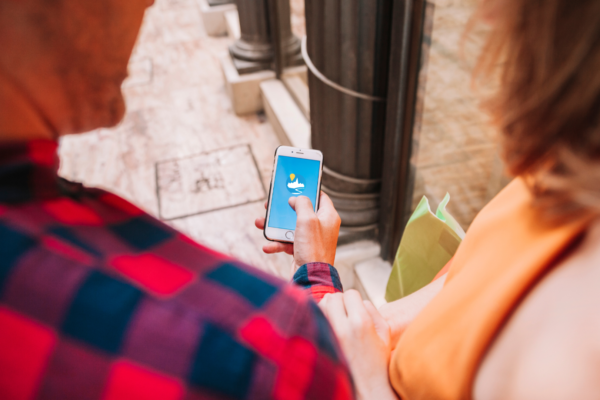 Un homme et une femme regardent le téléphone avec l'application de signalement de la ville de trélazé